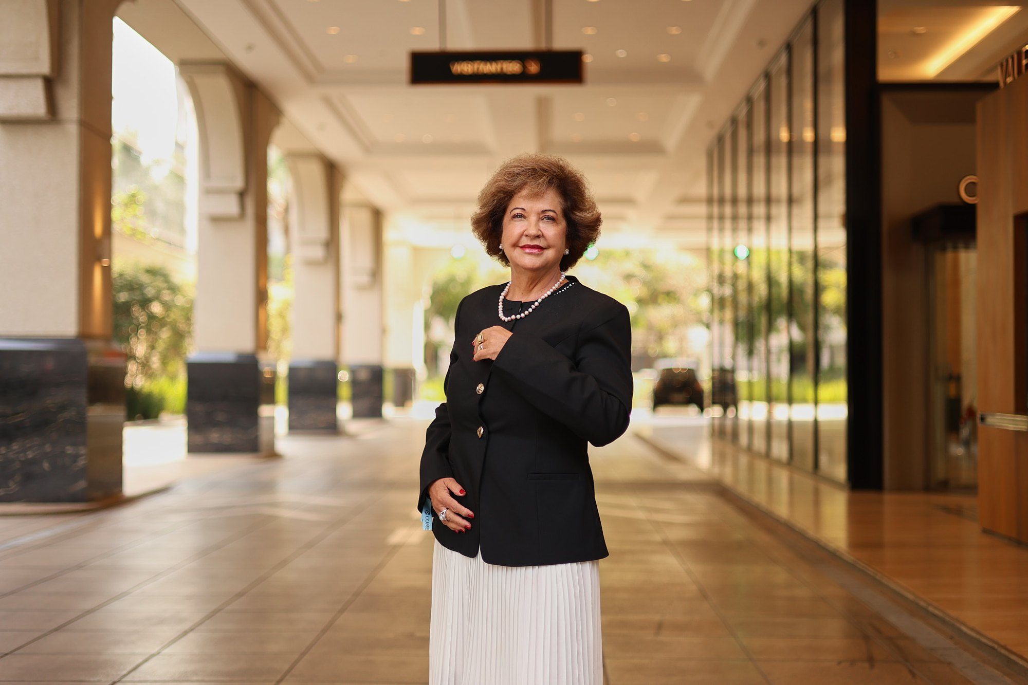 Dra. Miriam Mantovani caminhando em um saguão